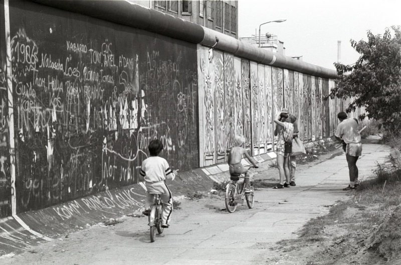 Kinder spielen an der Mauer