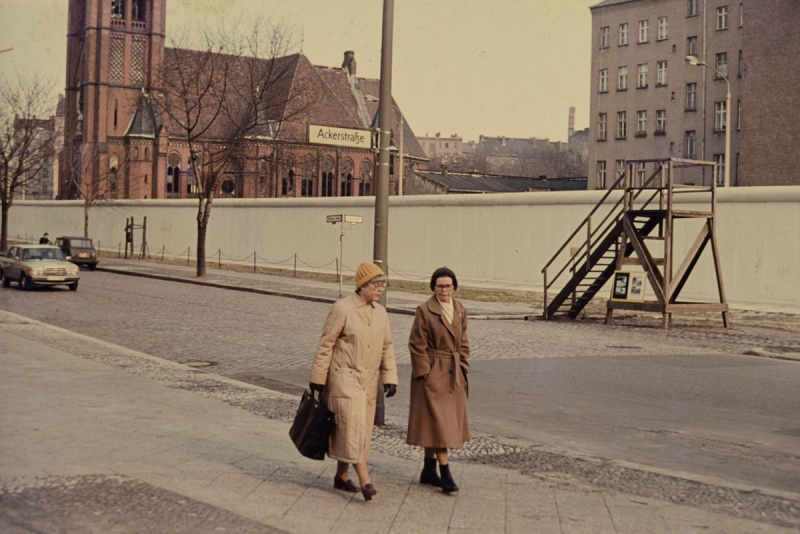 Zwei Frauen im Hintergrund die Mauer
