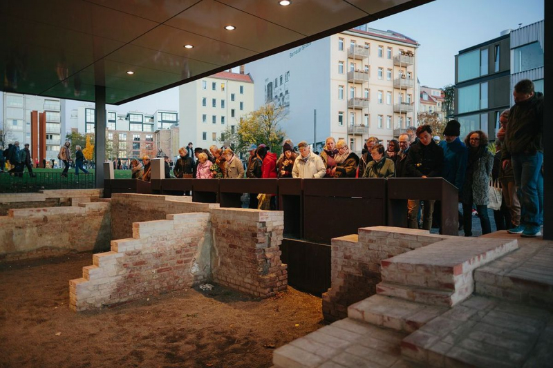 Überreste des Grenzhauses mit Besuchenden 